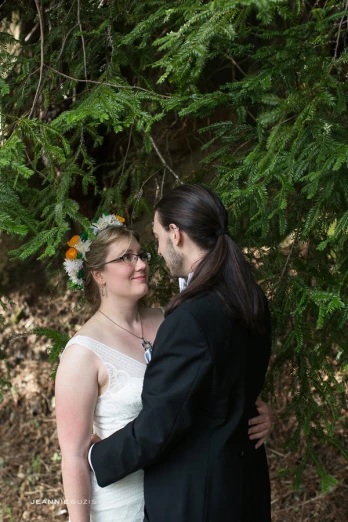 a beautiful young bride and groom posing in the forest