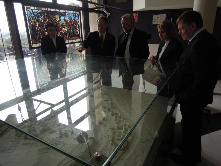 a group of businessmen standing around a table