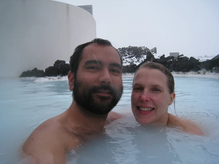 a man and woman enjoying a pool of water
