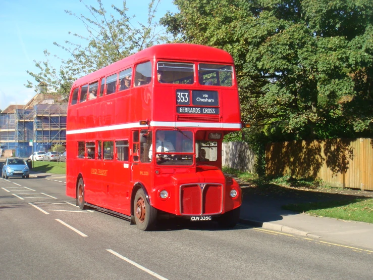 a red double decker bus driving down a road