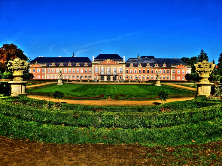 a beautiful building sitting near a green field and a path