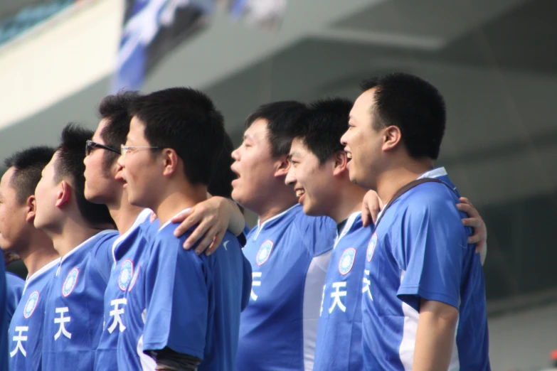 a group of guys in blue shirts standing in a line