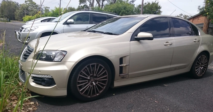 a white car parked on the side of a road next to other cars