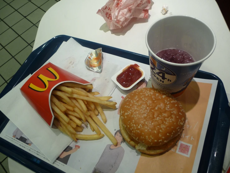 a tray with a burger, fries, ketchup and ketchup