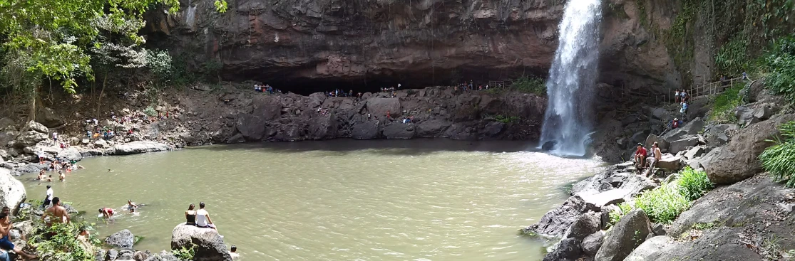 many people standing in front of a waterfall