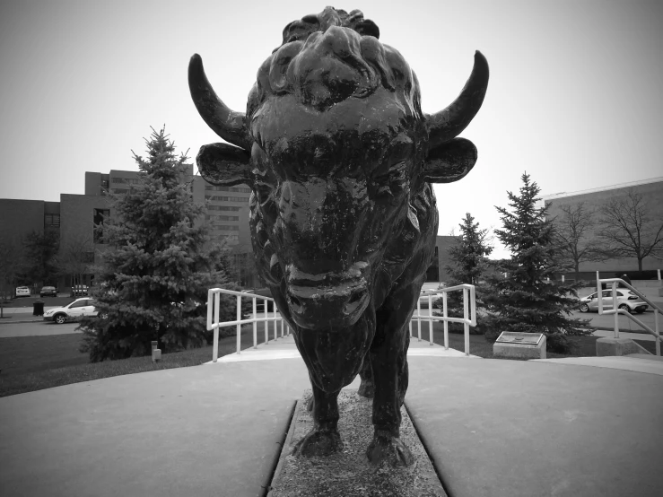 a bull statue sitting in the middle of a cement square