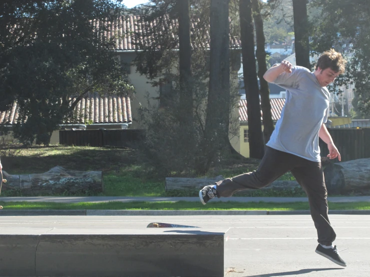 a young man is jumping his skateboard on the pavement