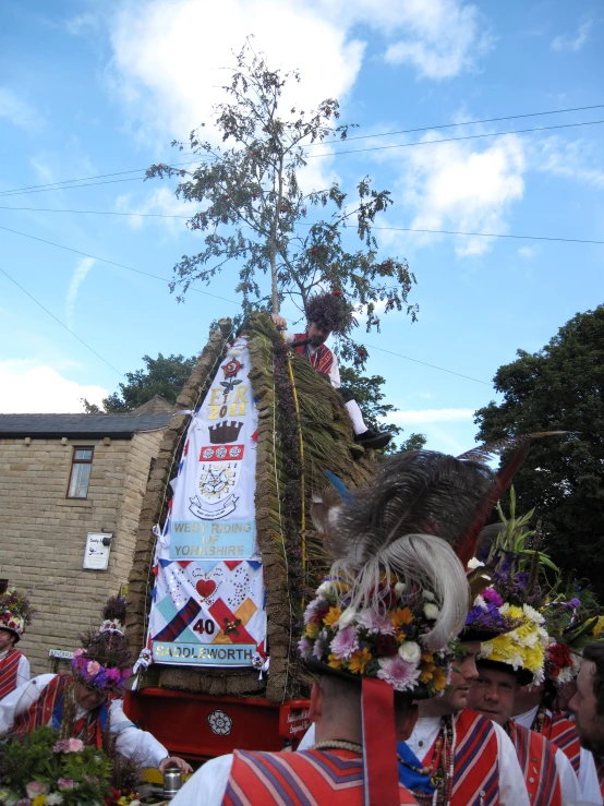 many people wearing colorful attire are standing near a float