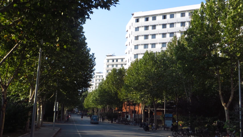 a small street between two buildings in the foreground and the sidewalk at one end is narrow