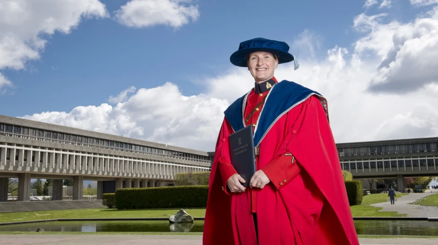 a woman in red robe and hat posing for a picture