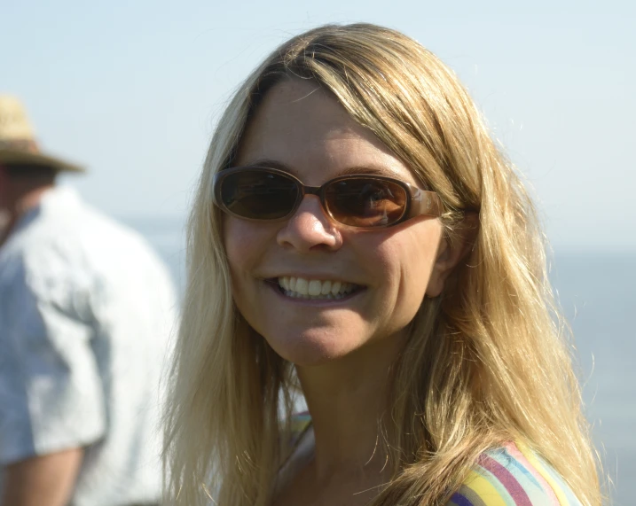 a woman wearing sunglasses standing in front of a man