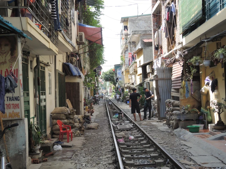 two people are walking along side a railroad track