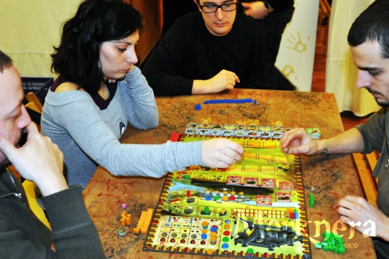 three men and a woman playing board games