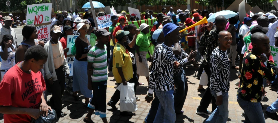 a crowd of people stand together holding umbrellas