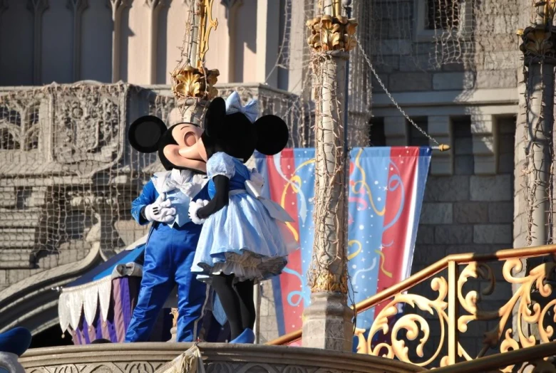 the large mickey mouse in blue and white suit is waving to people