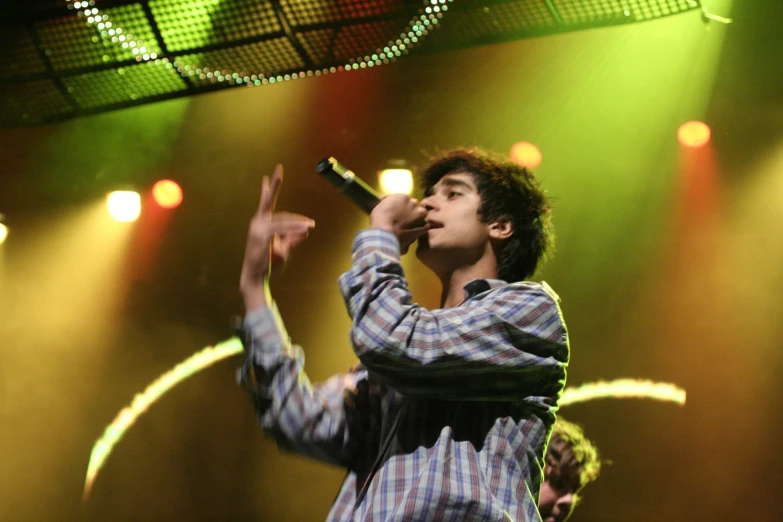 a man in striped shirt on stage holding microphone