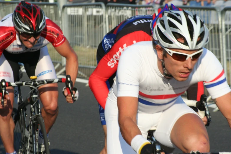 the two men are racing their bicycles down the road