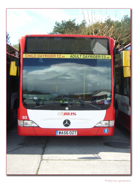 a red, white and black bus parked on the road