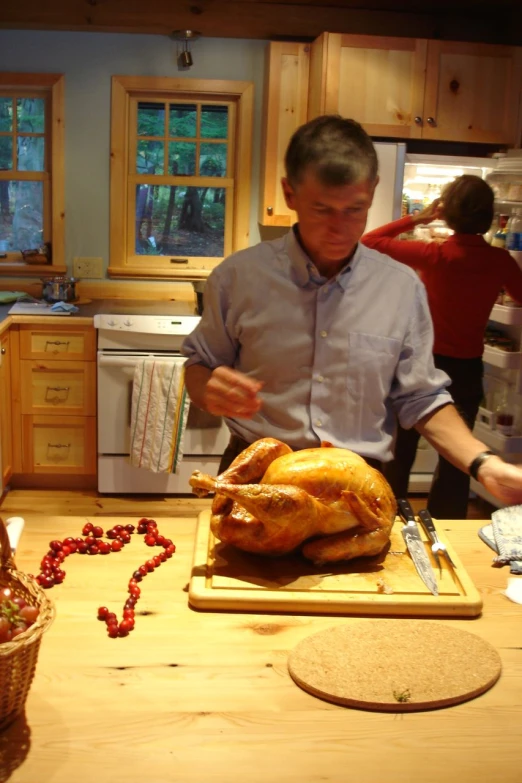 man at the kitchen counter  up a turkey