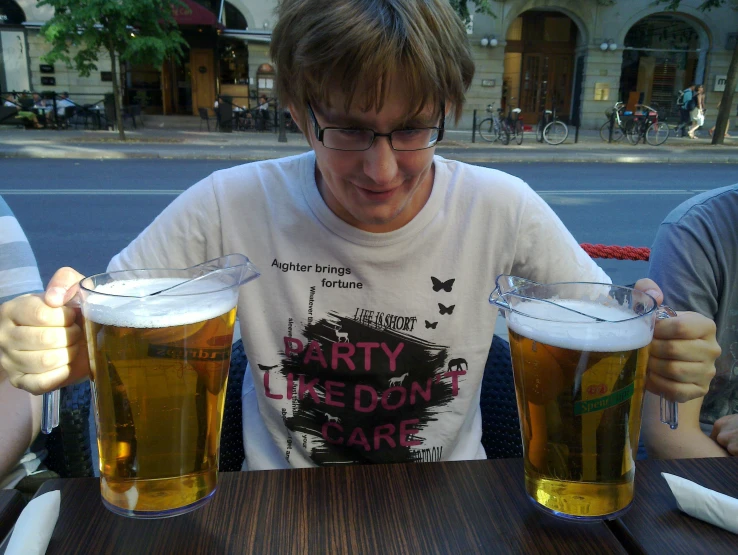 a man sits at a table with three mugs of beer
