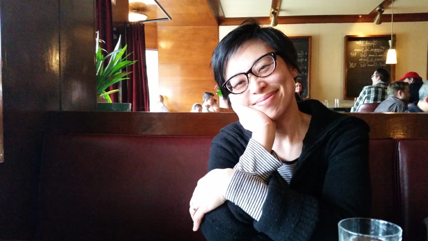 a lady at a table in a restaurant is sitting