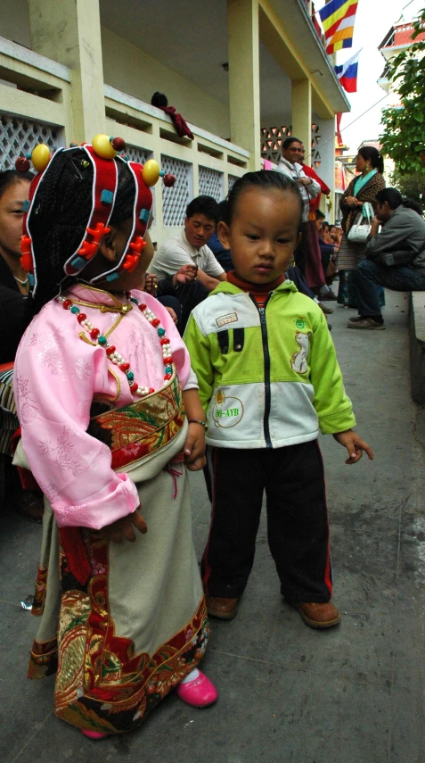 two little s wearing traditional chinese costumes standing next to each other