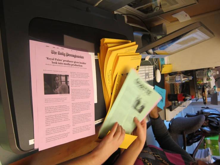 some people at a desk holding up a pink and yellow note