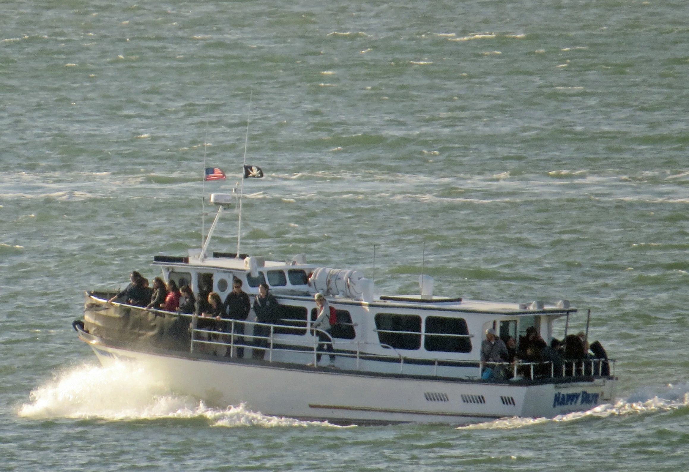 boat with people on deck traveling along water