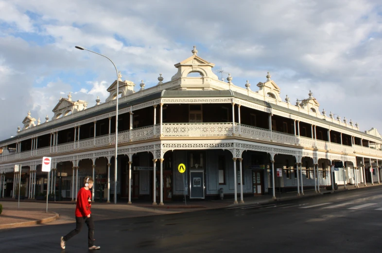 a man walking across the road in front of a store