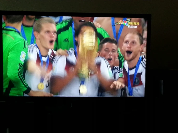 a group of people are cheering and holding their trophy