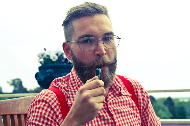 an image of man smoking a pipe in a park