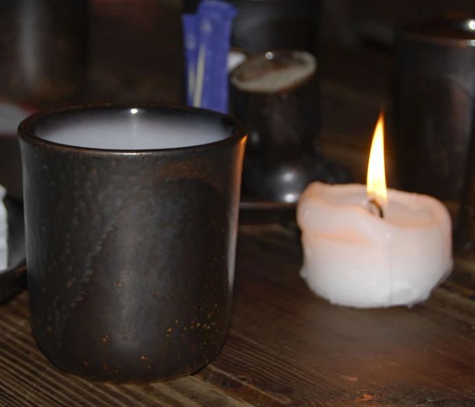 a candle on a table in front of two candles