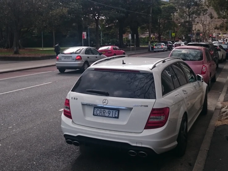 the back of a white mercedes wagon parked at a stop light