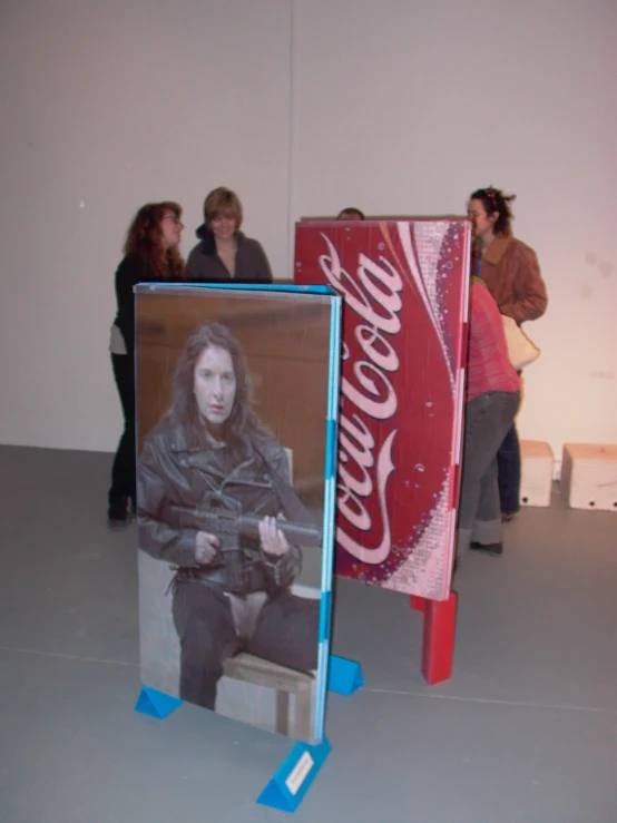 a po of a girl on a coke cooler in the middle of a museum display