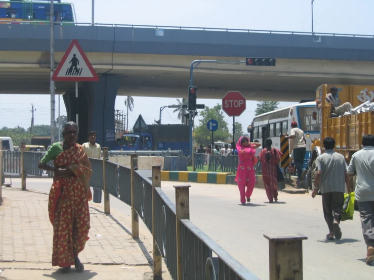 a group of people crossing a bridge over a street