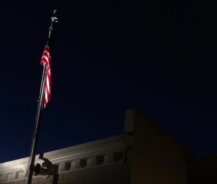 a large american flag on top of a building