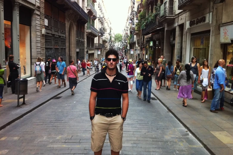 a man in black shirt standing on city street