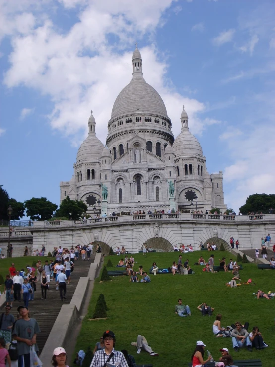 the building has many people around it in the grass