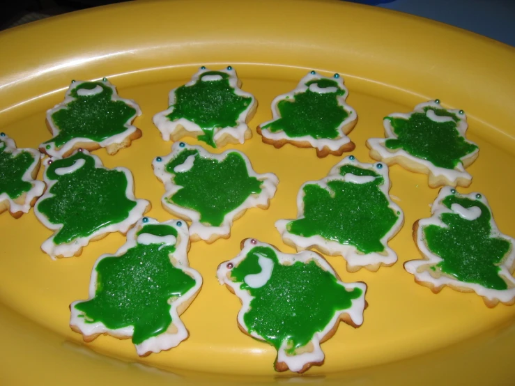 green and white iced cookie pieces on an orange plate