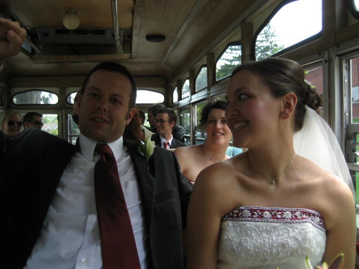 a man is taking a po while the bride and groom stand beside him