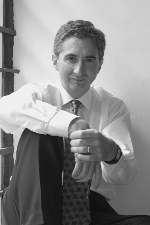 a black and white po of a young man tying a tie