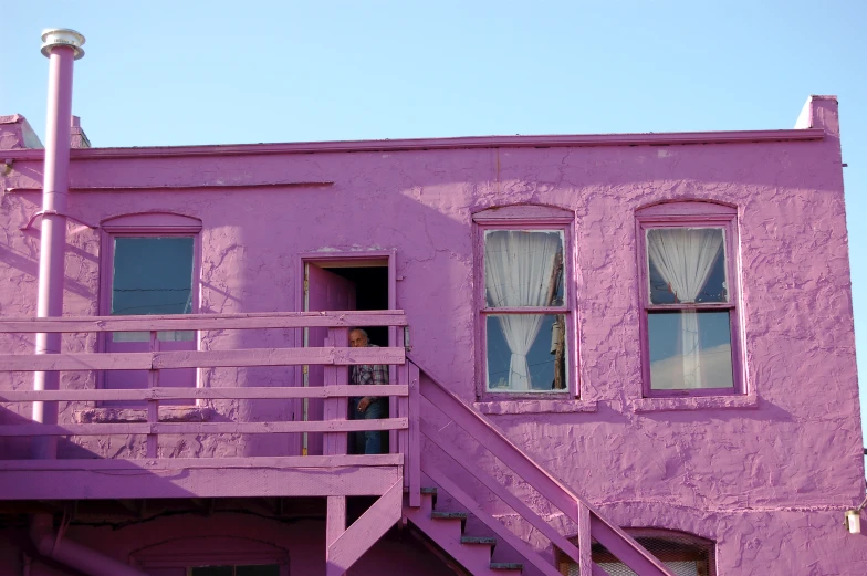 a pink building with two white windows