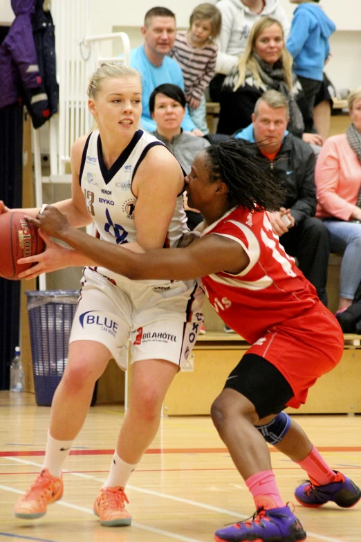 two women fighting for the basketball ball during a game