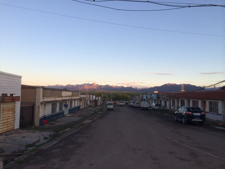 an empty street with parked cars in front