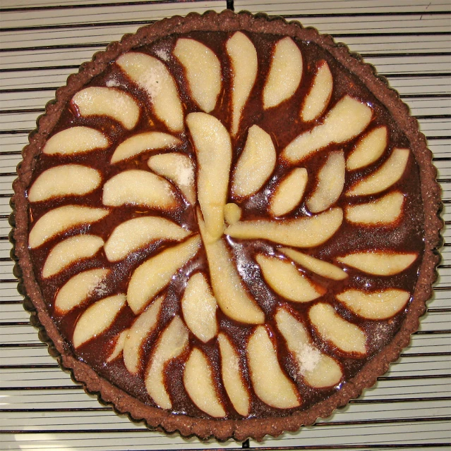 a cake with chocolate and apples on it sitting on top of a table