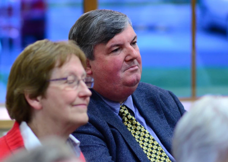 a man and woman sit next to each other at a microphone