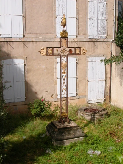 an old house with a tall cross next to it