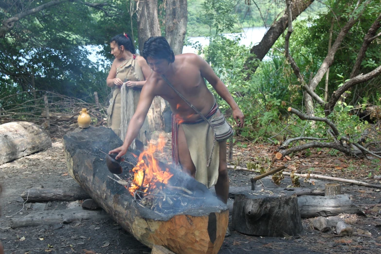 some people preparing food over an open fire