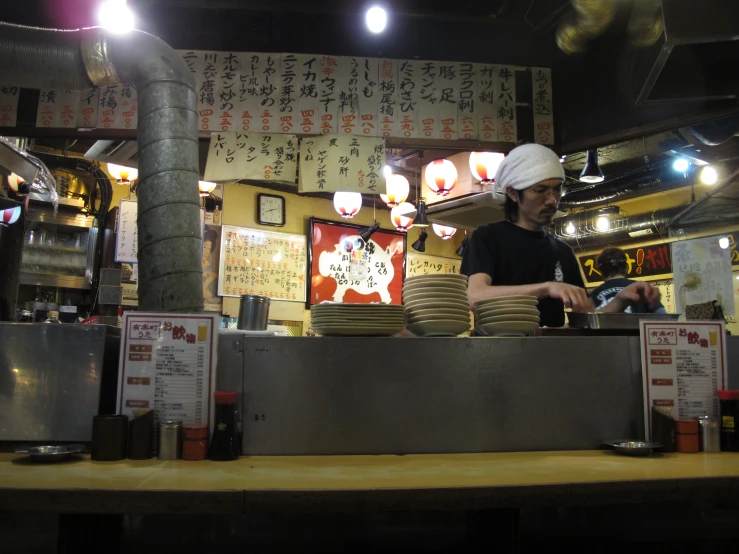 a restaurant attendant prepares food in front of an asian background