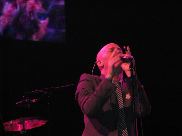 a man on stage singing at a concert